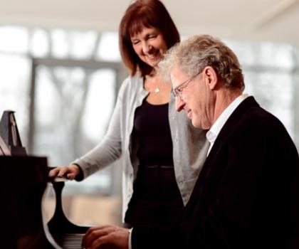 woman teaching adult man piano