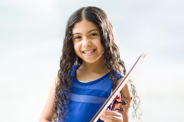 little girl holding violin set