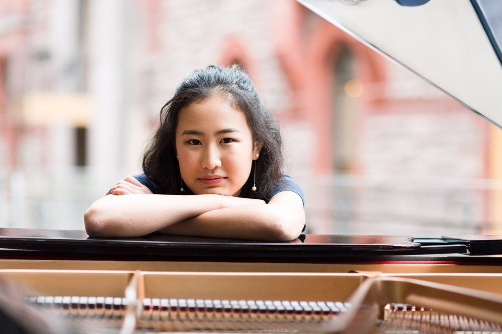 girl resting her chin on the piano